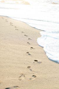 footprints in the sand near ocean